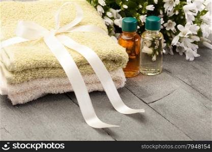 Photo of essential oil with towels over wooden table