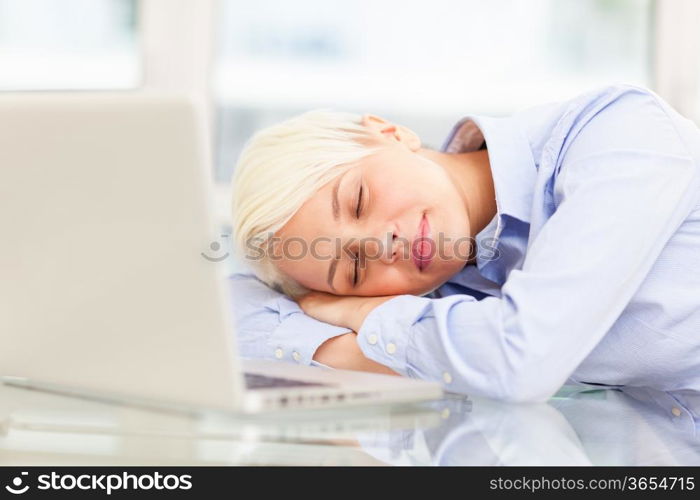 photo of exhausted businesswoman who sleeps on notebook