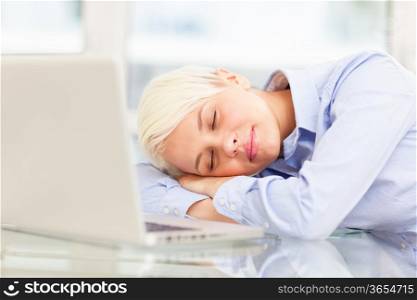 photo of exhausted businesswoman who sleeps on notebook