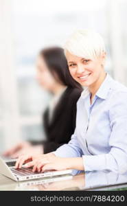 photo of female blonde employee working on her computer in office