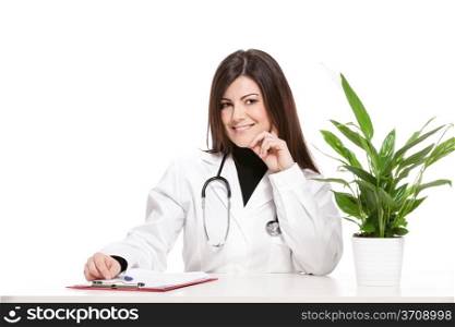 Photo of female doctor sitting at her desk and smiles towards the camera