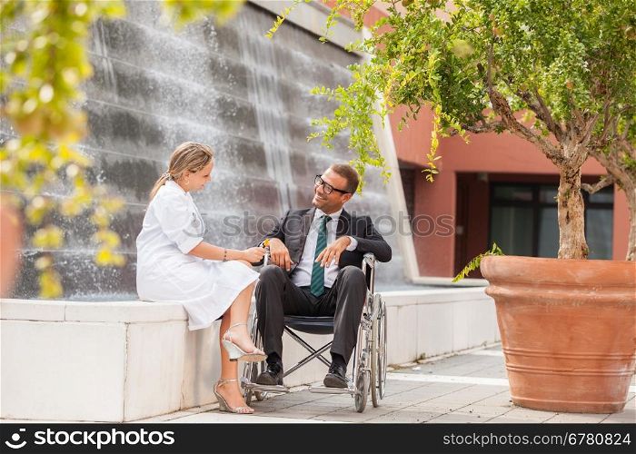 Photo of female doctor talking to businessman on wheelchair