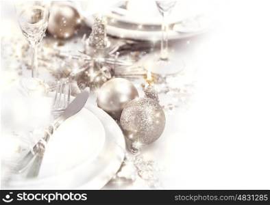 Photo of festive table setting decorated with beautiful silver bubbles and candles, luxury white utensil served with shiny cutlery, romantic holiday dinner, glasses for champagne, Christmas eve