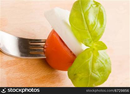 photo of fork with tomatoe and mozzarella on it