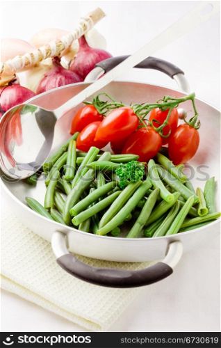 photo of french beans inside a pan with cherry tomatoes