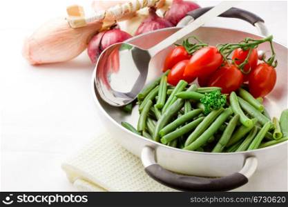 photo of french beans inside a pan with cherry tomatoes