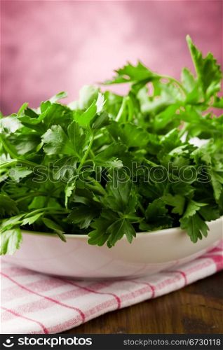 photo of fresh green parsley inside a bowl on wooden table