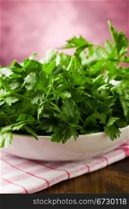 photo of fresh green parsley inside a bowl on wooden table