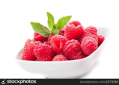 photo of fresh raspberries inside a bowl with mint on white background