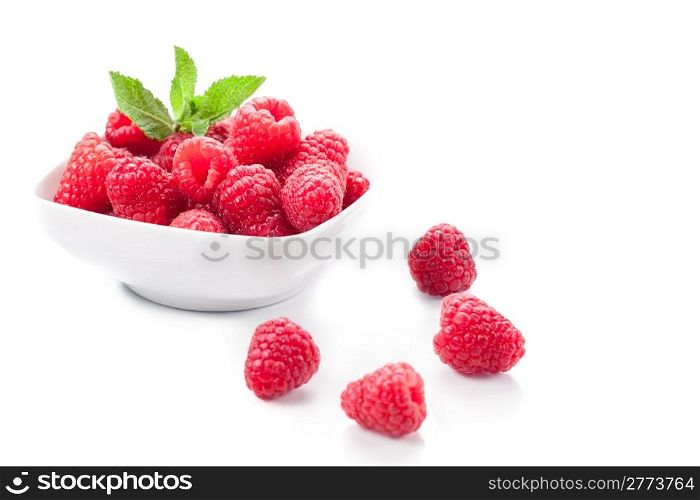 photo of fresh raspberries inside a bowl with mint on white background
