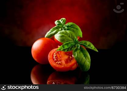 photo of fresh sliced tomatoes with basil on glass table with spot light