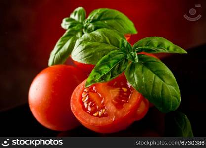 photo of fresh sliced tomatoes with basil on glass table with spot light