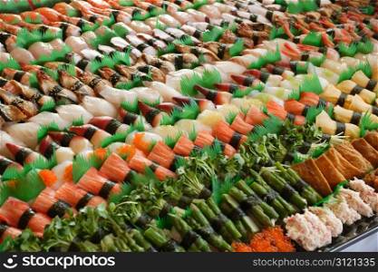 Photo of fresh sushi platter with a lot of variety. Selective focus on middle of the platter.