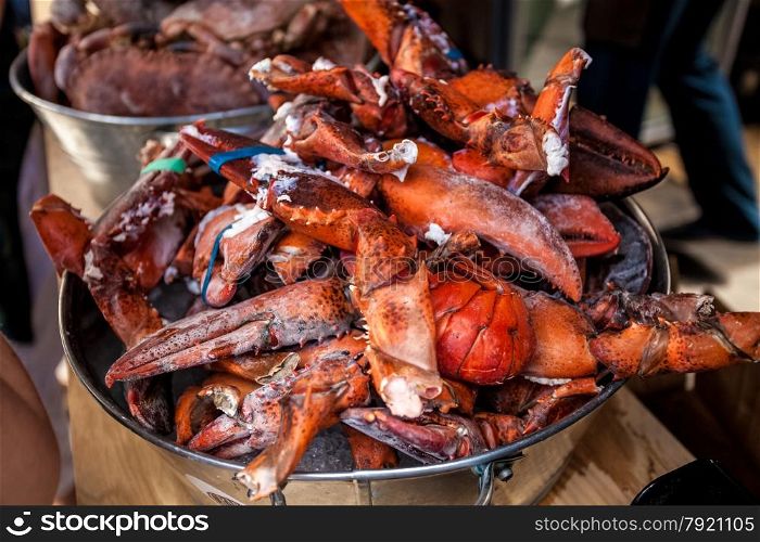 Photo of frozen lobster claws in metal bucket at restaurant