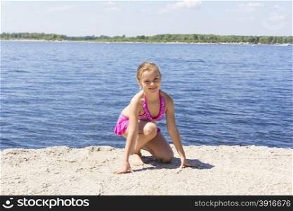 Photo of girl on the riverbank in pink swimsuit