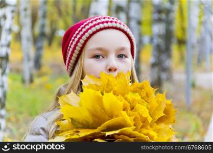 Photo of girl with bouquet from sheets in autumn