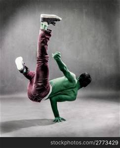 photo of green alien who is break dancing on the floor perfornming a freeze