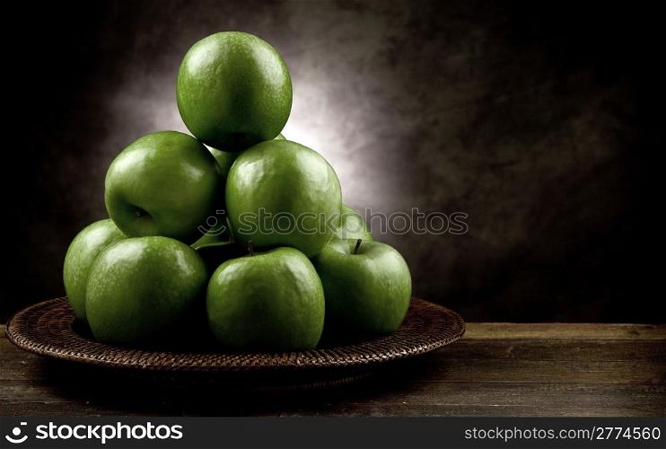 photo of green apples on wooden table in antique picturesque style