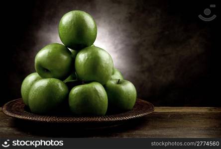 photo of green apples on wooden table in antique picturesque style