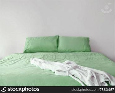 Photo of green bed with bath robe