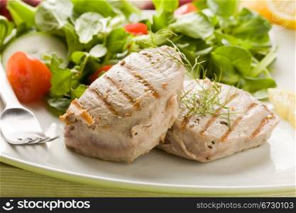 photo of grilled tuna steak with sald on green wooden table