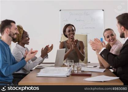 Photo of happy business people applauding at meeting focus on boss african girl