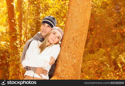Photo of happy lovers spending time together in autumnal park, attractive female with pretty male hugging in fall forest, boyfriend and girlfriend loving each other, autumn season, love concept&#xA;