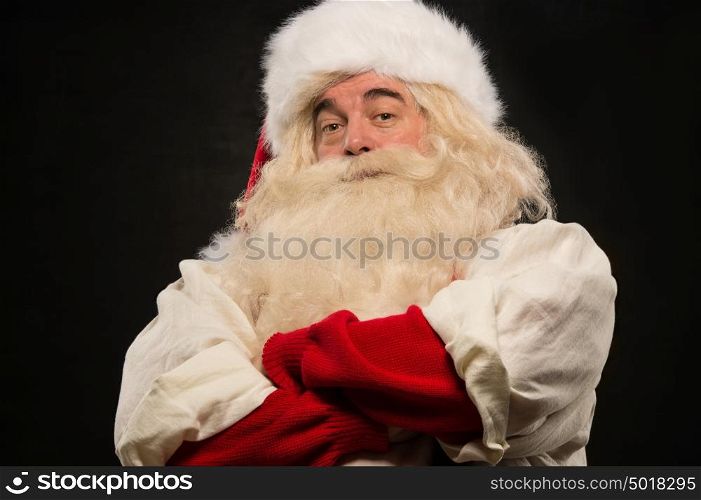 Photo of happy Santa Claus standing with hands folded and looking at camera