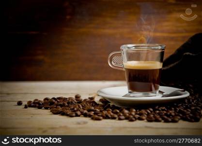 photo of hot smoking coffee inside glass cup on wooden table