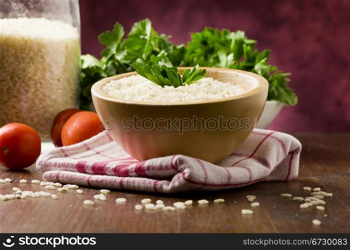 photo of ingredients for risotto with parsley on wooden table