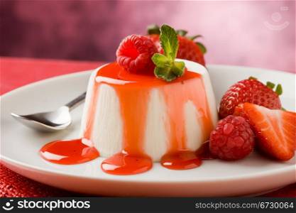 photo of italian panna cotta dessert with strawberry sirup and mint leaf
