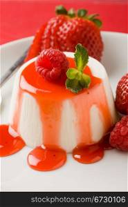 photo of italian panna cotta dessert with strawberry sirup and mint leaf