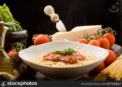 photo of italian spaghetti with tomatoe sauce and their ingredients arround