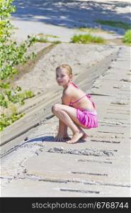 Photo of jumping girl on the riverbank in pink swimsuit