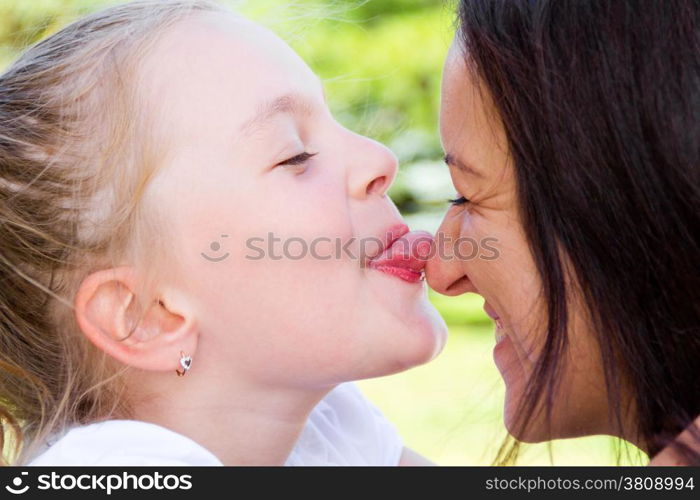 Photo of kissing mother and daughter in summer