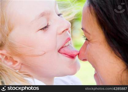 Photo of kissing mother and daughter in summer