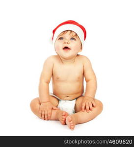 Photo of little baby boy wearing Santa Claus hat, small cute child sitting in diaper isolated on white background, lovely infant celebrate Christmas eve, New Year holiday, happiness concept