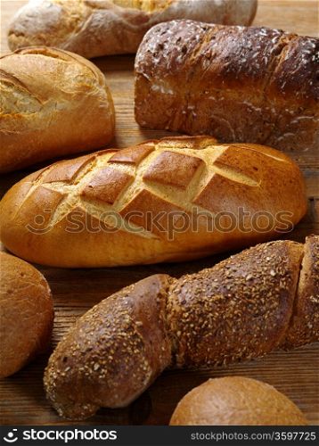 Photo of loaves of uncut bread resting on an old wood table.&#xA;