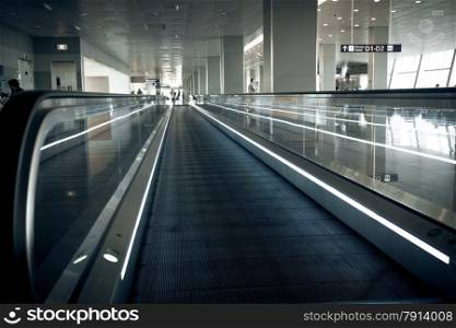 Photo of long horizontal escalator at international airport terminal