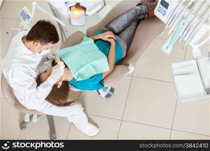 photo of male asian dentist doing his job on a young asian woman