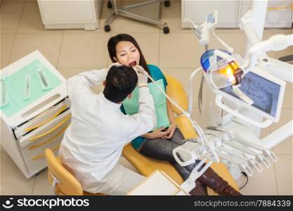 photo of male dentist doing his job on a asian young patient