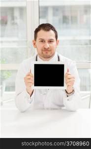 Photo of male doctor with tablet in his studio