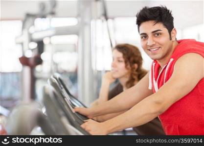 photo of man who is doing workout on a bicycle at the gym