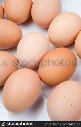 Photo of many brown hen eggs isolated over white