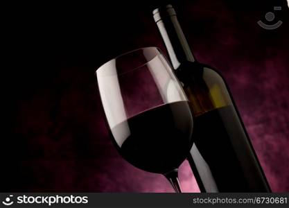photo of mature red wine with bottle in front of rural background