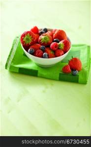 photo of mixed fresh berries on green table by day light