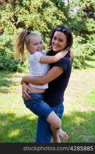 Photo of mother and daughter playing in summer