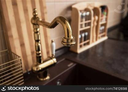 Photo of new modern kitchen interior. Luxury gold water tap. New modern kitchen interior