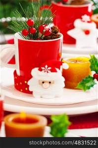 Photo of New Year eve table setting, closeup Christmas still life, Christmastime decoration for dinner, red and white festive utensil with candle and Santa Claus decoration, wintertime holiday