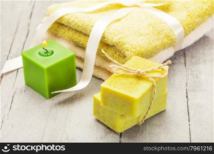Photo of olive soap and towels over wooden table